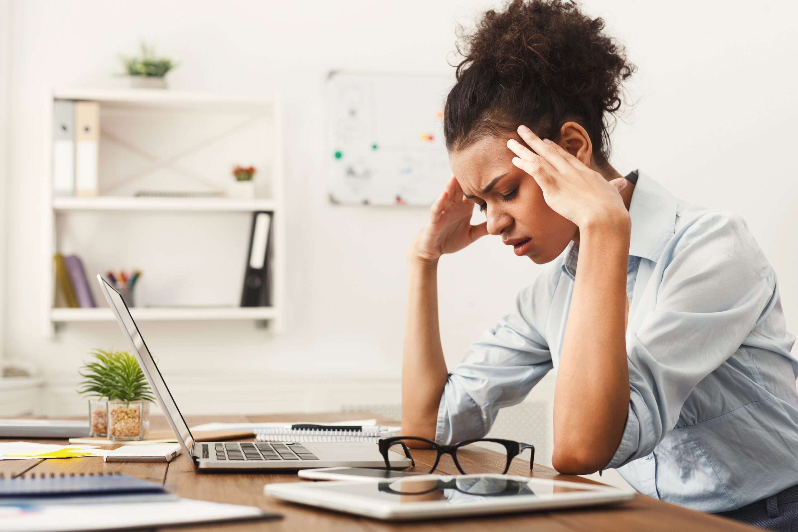 Tired business woman with headache at office feeling sick at work copy space