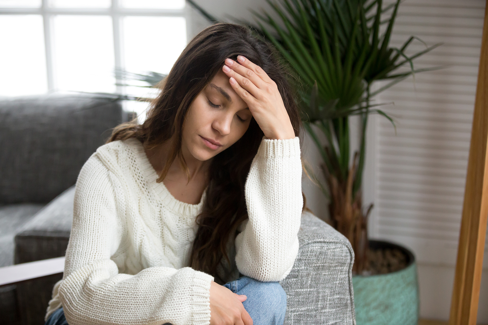 Frustrated tired young woman feeling strong headache touching forehead depressed upset girl suffering from migraine stressed worried teenager experiencing sudden panic attack or anxiety at home